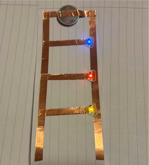 Prototype 4: Interactive circuit prototype using multiple LEDs connected via battery and copper tape.