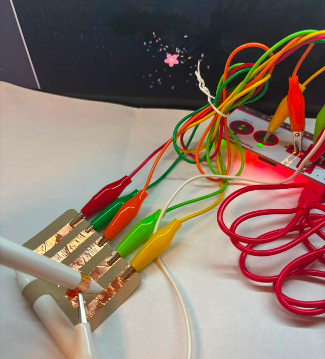 By using copper strips to connect the circuit with MakeyMakey, the control and visual effects can interact. (Object connections