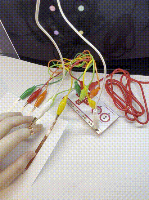 By using copper strips to connect the circuit with MakeyMakey, the control and visual effects can interact. (Hand connection